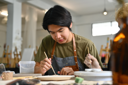 student working on ceramic piece in art class