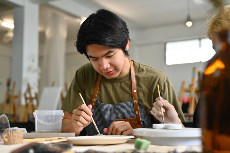 student working on ceramic piece in art class