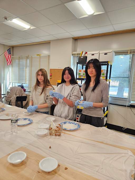 Chinese students assembling vegetarian and pork dumplings while watching CCTV gala program